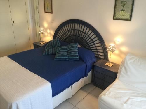 a bedroom with a large bed with blue sheets and pillows at Apartamento VenAVera Playa Jardines de Nuevo Vera L1-1D Primera Línea WIFI in Vera