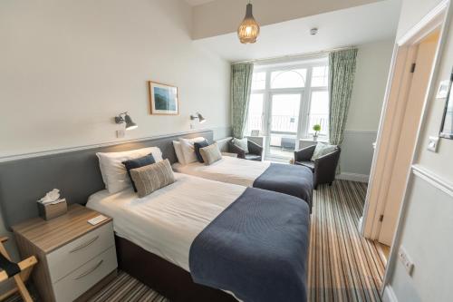 a hotel room with two beds and a window at The Kingswood Hotel in Sidmouth