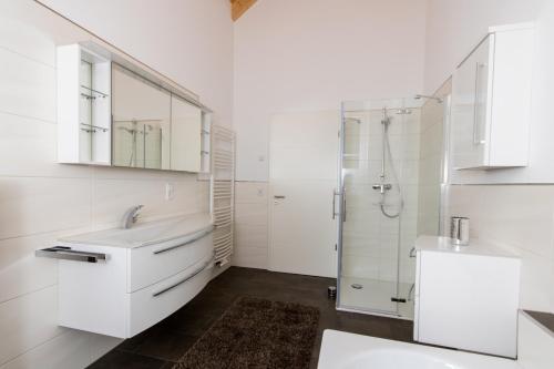 a white bathroom with a sink and a shower at Ferienwohnung Stratmann in Lennestadt
