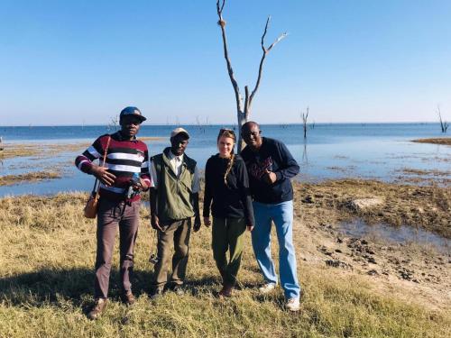 eine Gruppe von Menschen, die neben einem Wasserkörper stehen in der Unterkunft Naumba Camp and Campsite in Ngoma