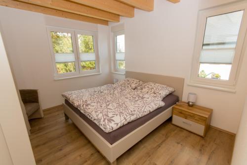 a bedroom with a bed and two windows at Ferienwohnung Stratmann in Lennestadt