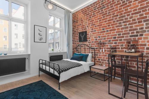 a bedroom with a bed and a brick wall at Green Panther right in the city of Wroclaw in Wrocław