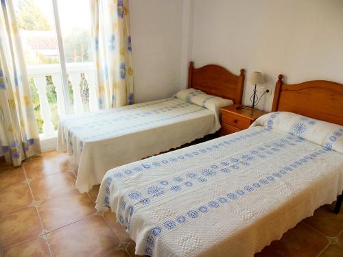two beds in a room with a window at Anamar Kione Rentals in Alcossebre