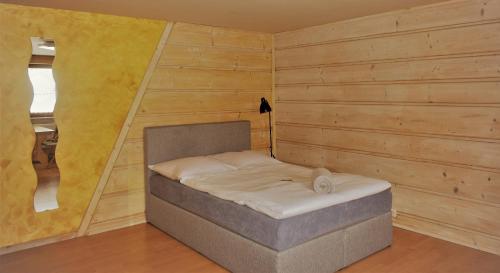 a small bed in a room with wooden walls at Apartament Fiedorówka in Zakopane