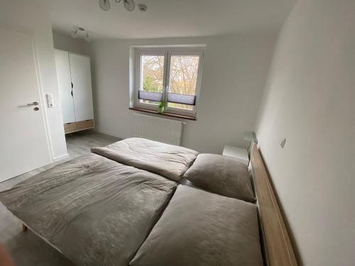 uma cama grande num quarto com uma janela em Schöne Ferienwohnung in Landsberg em Landsberg