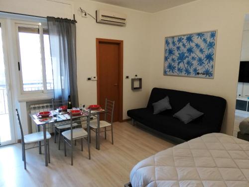 sala de estar con cama, mesa y sofá en Parco del Mare Pescara Apartments, en Pescara