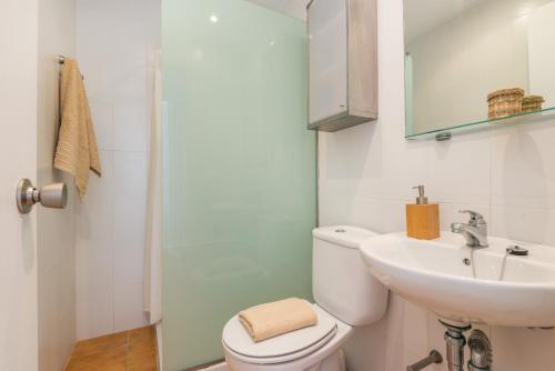ein Badezimmer mit einem weißen WC und einem Waschbecken in der Unterkunft Apartamento Savina-Arenal den Castell in Es Mercadal