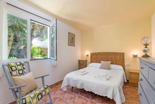 sypialnia z łóżkiem i oknem w obiekcie Villa Mari - Calan Porter w mieście Cala'n Porter