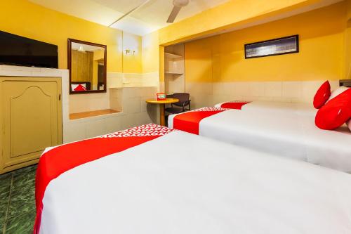 a hotel room with two beds and a television at Hotel San Marcos in Los Mochis