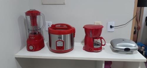 un mostrador con dos mezcladores rojos en un estante en Parque ALDEIA DAS ÁGUAS Village flat, en Barra do Piraí