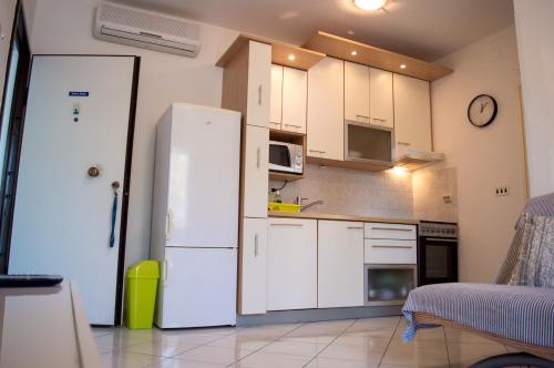 een keuken met witte kasten en een witte koelkast bij Privlaka's Sun&Sea in Privlaka