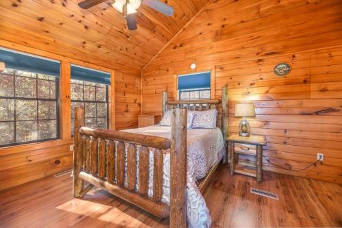 ein Schlafzimmer mit einem Bett in einem Blockhaus in der Unterkunft Secluded Cabin Near Smoky Mountains. Hot Tub! Honeymoon! in Sevierville