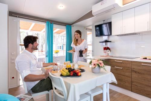 a man and a woman standing in a kitchen at Ca' Pasquali Village in Cavallino-Treporti