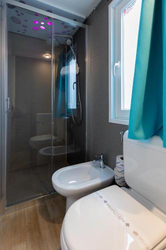 a bathroom with a shower and a toilet and a sink at Ca' Pasquali Village in Cavallino-Treporti