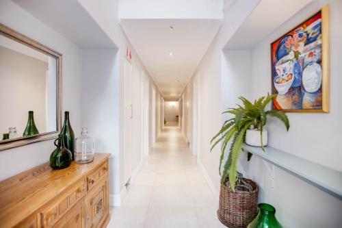 a hallway with white walls and a wooden dresser at Amberhall Guesthouse in Johannesburg