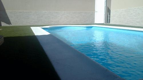 a swimming pool with blue water in a house at Mar&Mar, apartamento con solárium y piscina in Gran Tarajal