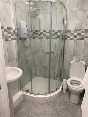 a bathroom with a shower and a toilet and a sink at Nantwich House in Crewe
