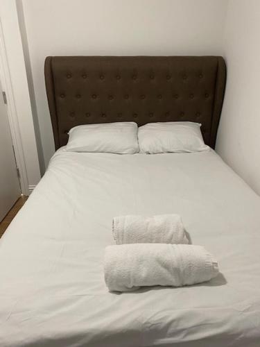a white bed with two towels on top of it at Nantwich House in Crewe