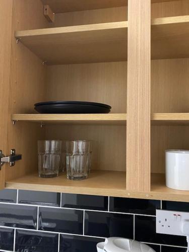 a kitchen shelf with a bowl and glasses on it at Nantwich House in Crewe