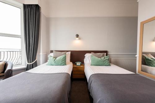 a hotel room with two beds and a window at The Elizabeth in Sidmouth
