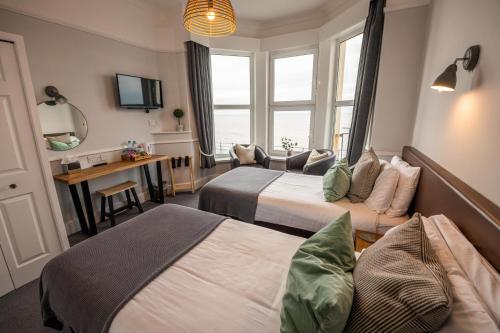Habitación de hotel con 2 camas y escritorio en The Elizabeth, en Sidmouth