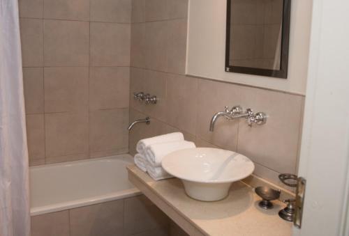 un baño con lavabo y bañera en La Bonita Apartment, en San Carlos de Bariloche