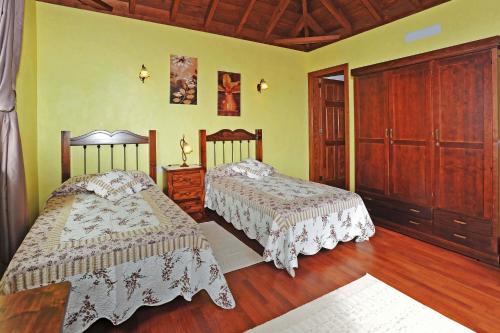 1 dormitorio con 2 camas y suelo de madera en Villa Lomo Gonzalez, en Tijarafe