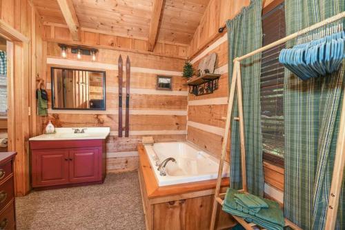 ein Bad mit einer Badewanne, einem Waschbecken und einer Dusche in der Unterkunft View! Cozy, Private, Fireplace, Hot Tub Log Cabin, Honeymoon! in Sevierville