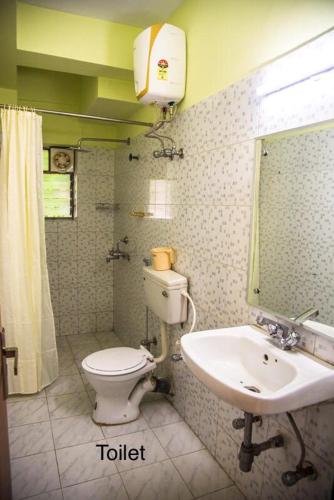 a bathroom with a toilet and a sink at Emerald By Olys Apartment in Kolkata