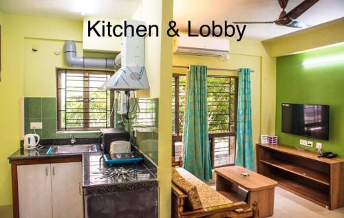 a kitchen with green walls and a kitchen and lobby at Emerald By Olys Apartment in Kolkata