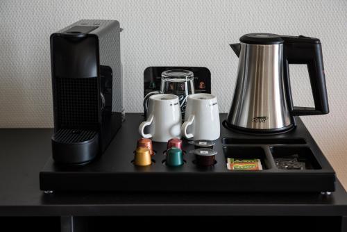 a black counter with a coffee maker on it at Fruitpark Hotel & Spa in Ochten