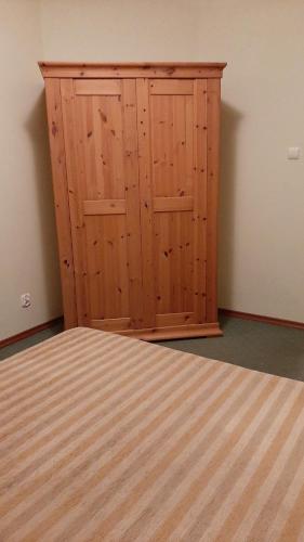 um quarto com uma cama e um armário de madeira em Pokoje Herta - Domek letniskowy em Stawiguda