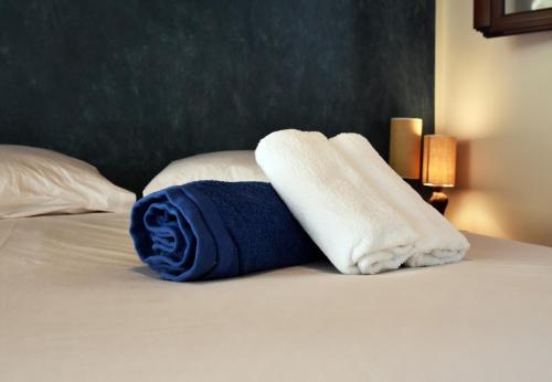 a bed with two towels on top of it at family home with a fantastic sea view, 5 minutes from the beaches in Koundouros