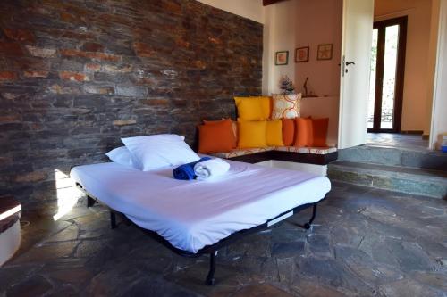 a large bed in a room with a brick wall at family home with a fantastic sea view, 5 minutes from the beaches in Koundouros
