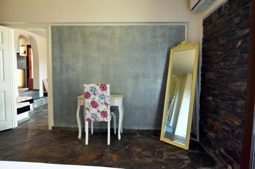 a room with a table with a chair and a mirror at family home with a fantastic sea view, 5 minutes from the beaches in Koundouros