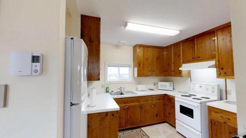 a kitchen with wooden cabinets and a white refrigerator at Bayview Pines Country Inn B&B in Mahone Bay