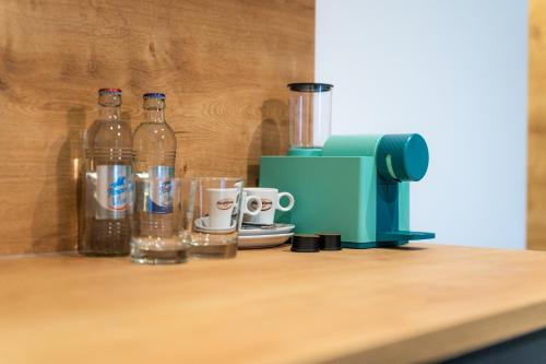 a counter with bottles of water and a blender at Hotel No151 in Differdange