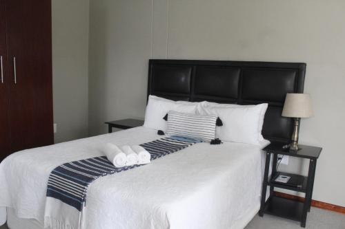 a bedroom with a bed with two towels on it at The Anne Guest House in Maseru