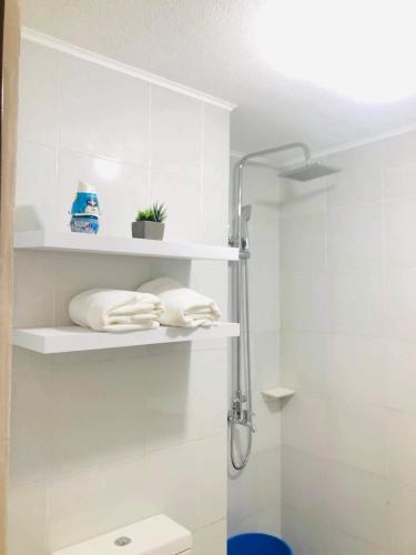 a bathroom with white shelves and a shower at Lou Condo Rental in Cagayan de Oro