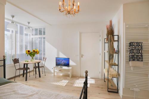 阿姆斯特丹的住宿－Boutique Studio Magielsen，一间卧室配有一张桌子、一张床和一个吊灯。