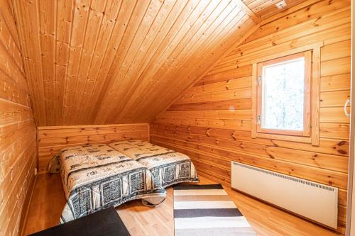 a bedroom in a log cabin with a bed at Rentorakka in Kittilä