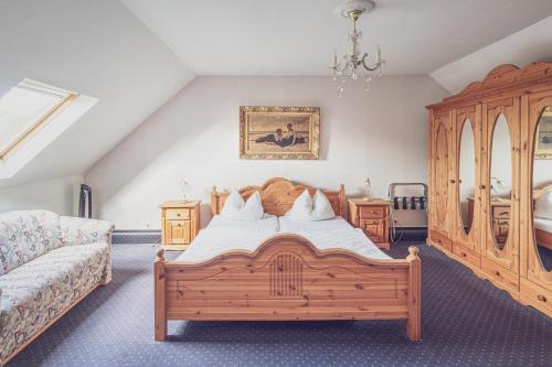 1 dormitorio con cama grande de madera y sofá en Schloß Destille, en Dormagen