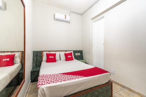 a bedroom with a bed with red pillows at OYO Hotel Dom Pedro, São Paulo in São Paulo