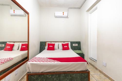 a bedroom with two beds with red pillows at OYO Hotel Dom Pedro, São Paulo in São Paulo