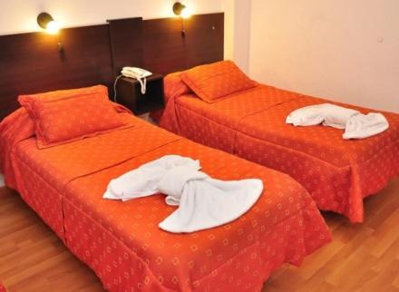 two beds in a hotel room with towels on them at BALOO Hotel in Mar del Plata