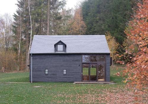 a small black house with a gambrel roof at Chalet d'Orti in Sainte-Ode