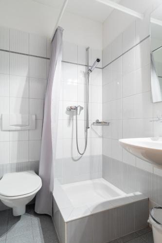 a bathroom with a shower and a toilet and a sink at Hotel Bellevue in San Bernardino