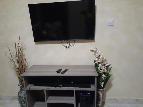 telewizor z płaskim ekranem wiszący na ścianie w obiekcie Royal studio in Kitengela w mieście Athi River