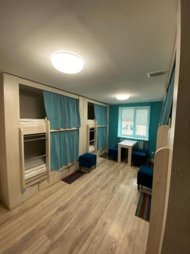 an empty room with blue walls and wooden floors at Hostel Zolota Nyva in Chortkiv
