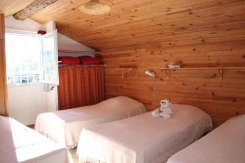 a room with three beds and a teddy bear sitting on top of them at Verdon Vacances in Saint-André-les-Alpes